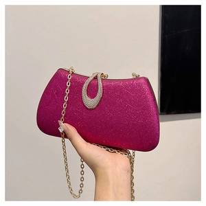 Close-up of fuchsia sequin evening bag with gold metal frame and rhinestone clasp