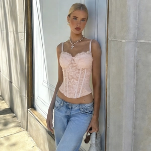 Détails rapprochés du caraco en dentelle rose montrant les textures et les bordures