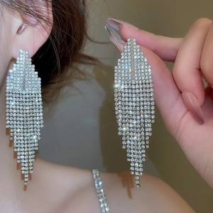 Gros plan détaillé de longues boucles d'oreilles à franges argentées avec strass