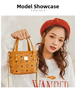 Detail of printed bucket bag with metal logo plaque and detachable shoulder strap