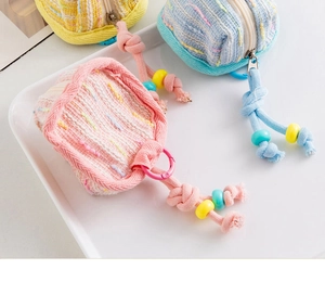Vue rapprochée de mini pochettes tissées colorées avec fermetures éclair et cordons perlés
