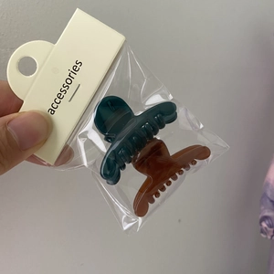 Detailed packaging showing matte dark green and reddish brown mini hair claw clips