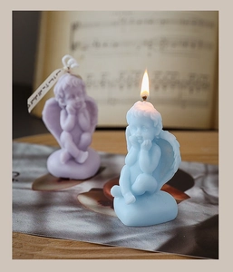 Artistic detail of a lit blue angel scented candle with soft melting wax on sheet music