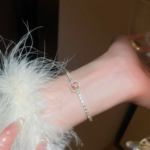 Detail of adjustable gold bracelet with rectangular pink zircon and crystal accents