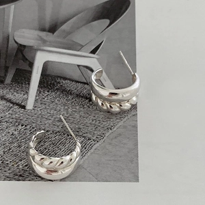Detailed macro view of S925 sterling silver layered hoops with twisted texture detail