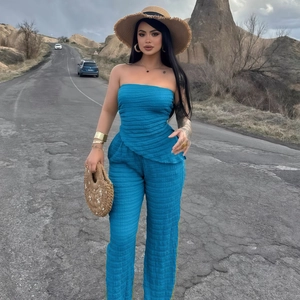 Détail de la texture plissée bleue sur le haut bustier et le pantalon large