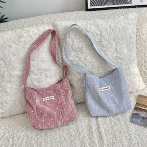 Détail de sacs bandoulière en velours avec motifs de cœur en rose et bleu