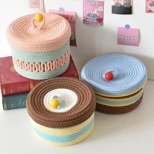 Detail of colorful woven cotton storage baskets with decorative lids and handles