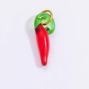 Close-up of a glass chili pepper pendant with vibrant red and green colors and gold loop
