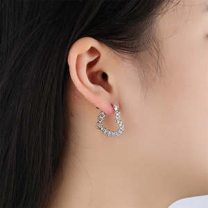 Vue détaillée de boucles d'oreilles créoles cœur en argent sur mannequin pour référence