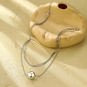 Minimalist multi-layered stainless steel necklace featuring a polished silver ball pendant