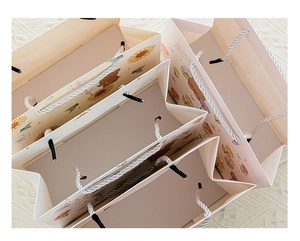 Detailed top view of cartoon gift bags with thickened paper texture and cotton rope handles