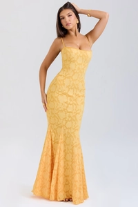Detail des gelben Jacquard-Stoffs mit Blumenmuster an einem figurbetonten Maxikleid