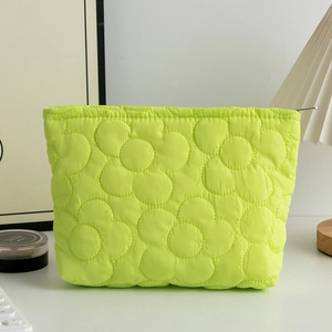 Dettaglio del motivo floreale trapuntato verde neon su astuccio per cosmetici