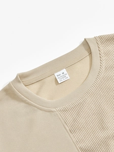 Close-up of beige crew neck sweatshirt collar showing rib texture and size label