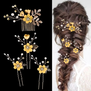 Detail of yellow floral bridal hair piece set with golden leaves and pearls for hair styling