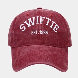 Close-up of white Swiftie 1989 embroidery on vintage washed burgundy baseball cap