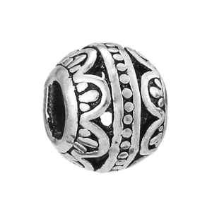 Detailed macro view of retro silver beaded charm with engraved bohemian floral patterns