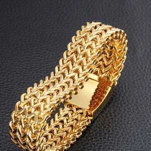 Macro view of gold-plated stainless steel fish-scale link bracelet with square clasp.