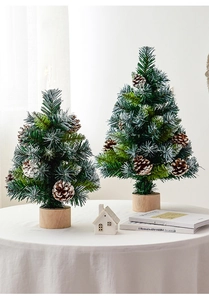 Mini frosted Christmas trees with pine cones on wooden bases for festive tabletop decor