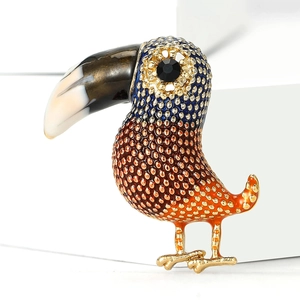 Macro shot of colorful enamel toucan brooch with orange and blue gradient and gold dots