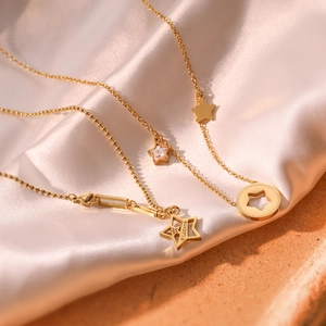 Gold star pendant necklace with lucky engraving and zircon on silk background