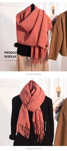 Detailed close-up of coral pink cashmere-like scarf with colored dots and fringe edges