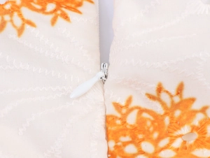 Detalle de la cremallera invisible y el bordado floral en la tela del vestido crudo
