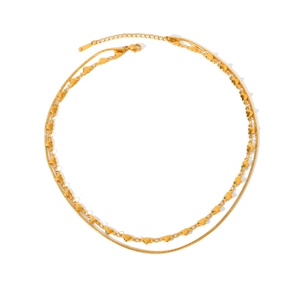 Detailed view of a layered gold-plated necklace with small heart charms and snake chain