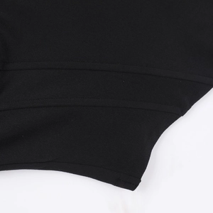 Détail du zoom sur l'ourlet à double surpiqûre et la maille d'un haut noir ajusté sexy