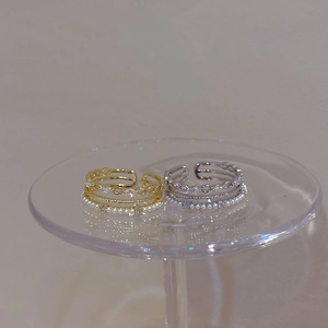 Detailed view of layered rings with imitation pearls and pavé cubic zirconia accents