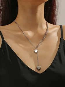 Detail of silver double-layered heart necklace with polished pendants on a model