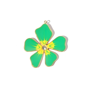 Macro shot of gold-plated flower charm with green enamel and crystal center detail
