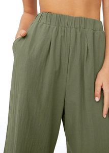 Gros plan du pantalon large vert foncé montrant la taille élastique et la poche latérale