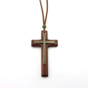 Detailed close-up of a rustic wooden and bronze metal double-layer cross pendant