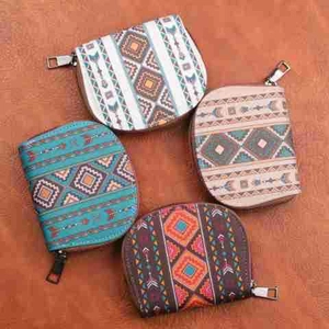 Flat lay of small semi-circular coin purses with bohemian geometric patterns and metal zippers