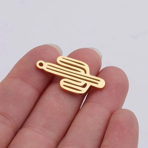 Close-up of a hand holding a polished golden cactus pendant with hollow design