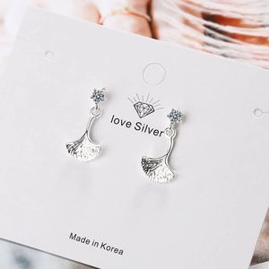 Vue macro détaillée des boucles d'oreilles en argent feuille de ginkgo avec zircon brillant