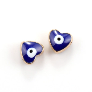 Macro shot of two heart-shaped evil eye pendants in blue enamel and gold finish