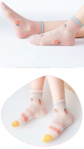 Détail de chaussettes en maille rose pour bébé avec fraises et pointes jaune vif