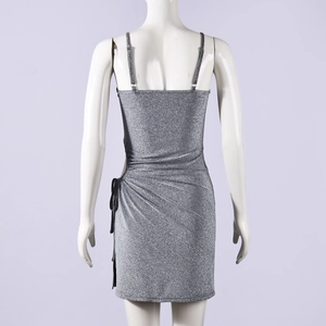 Détail d'une mini robe argentée à paillettes avec bretelles au dos et taille froncée