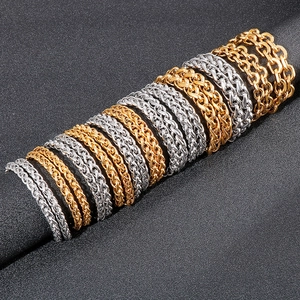 Detail of woven keel chain necklaces in gold and silver finish on black background