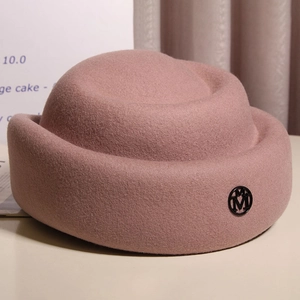 Elegant pink wool felt cloche hat with a vintage round crown and metallic logo detail
