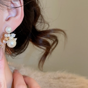 Détail de boucles d'oreilles plaquées or 14 carats avec zircons et perles blanches élégantes