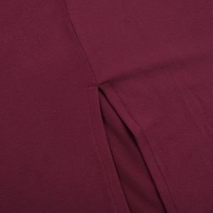 Detailed view of the burgundy knit fabric featuring a side slit and precise stitching