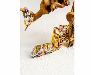 Detail of gold-plated eternity rings with colorful cubic zirconia on a wooden stand