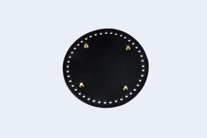 Detail of 15cm round black PU leather bag base with gold metal studs and pre-drilled holes
