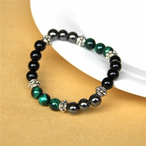Macro detail of natural tiger eye beads and black stones with engraved silver spacers