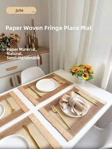 Macro detail of paper and jute woven placemats with fine fringe trim on a white table