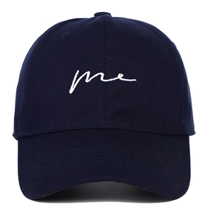 Detailed view of navy blue cotton baseball cap with white 'me' letter embroidery